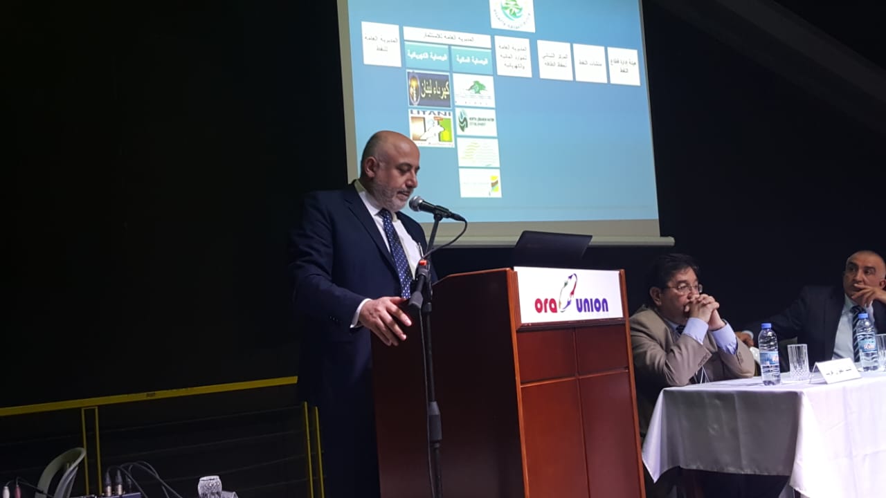 Joseph Deeb, adviser to the Minister of Energy and Water, addressing the Forum of Opportunities and Capacities, February 2018, with the Ministry of Energy and Water institutional structure displayed behind him